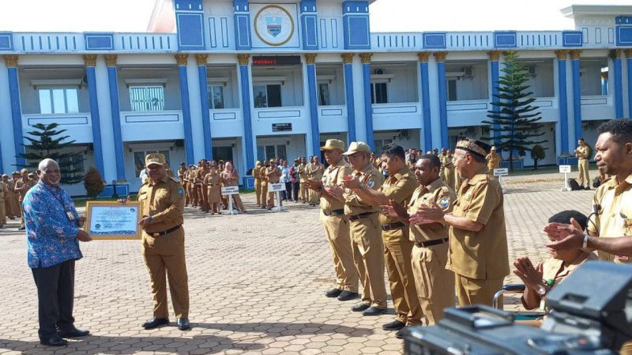 Kepala Kantor Ombudsman RI perwakilan Papua Barat Musa Yosep Sombuk (baju batik) menyerahkan penghargaan pelayanan publik kepada Pemerintah Kabupaten Manokwari, Senin. (ANTARA/Fransiskus Salu Weking)