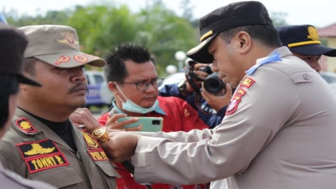 Kapolres Gunung Mas AKBP Asep Bangbang Saputra menyematkan tanda operasi kepada salah satu perwakilan Satpol PP, saat upacara gelar pasukan Operasi Keselamatan Telabang 2023 di Kuala Kurun. (ANTARA/HO-Polres Gunung Mas.)