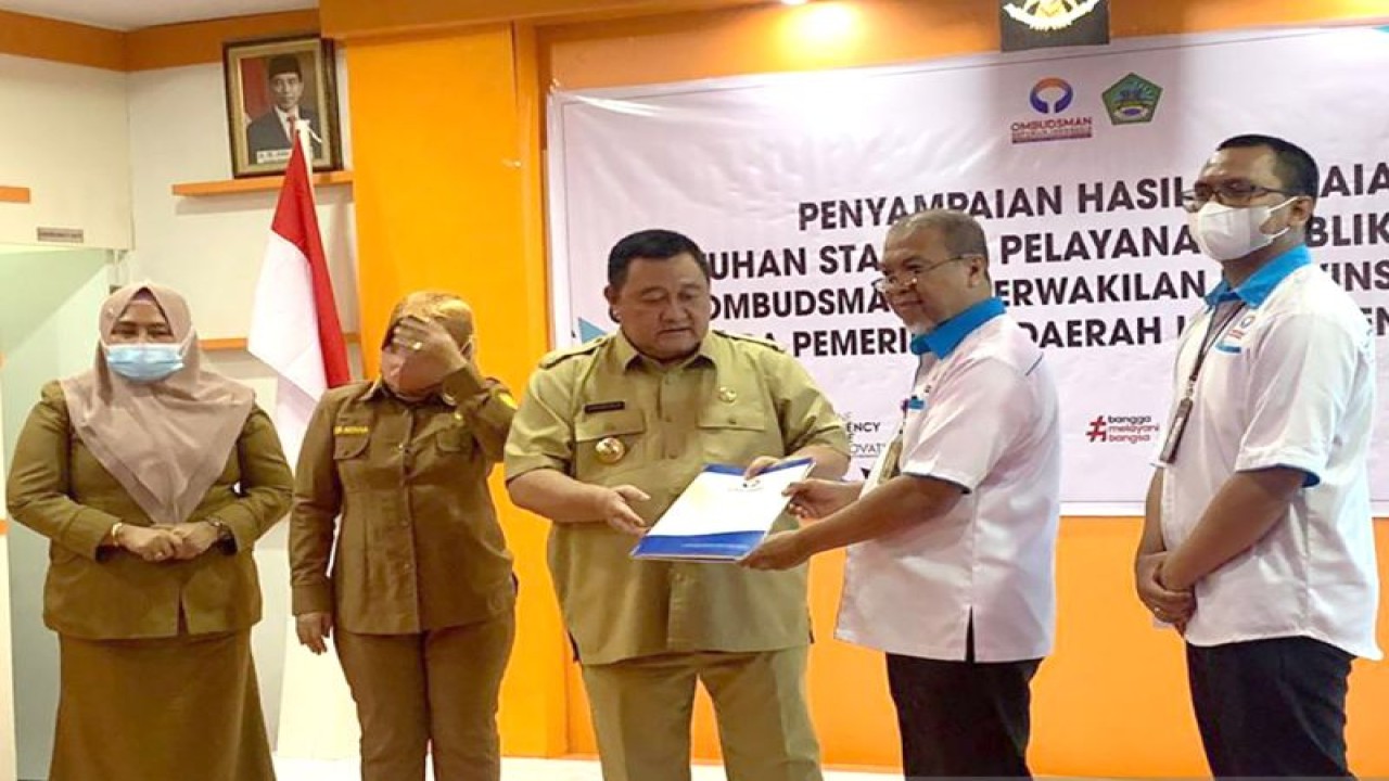 Kepala Perwakilan Ombudsman Gorontalo Alim S. Niode (kedua kanan) menyerahkan hasil penilaian penyelenggaraan pelayanan publik tahun 2022 kepada Penjabat Bupati Boalemo Hendriwan (tengah) di Kabupaten Boalemo, Gorontalo. ANTARA/HO-Ombudsman Gorontalo