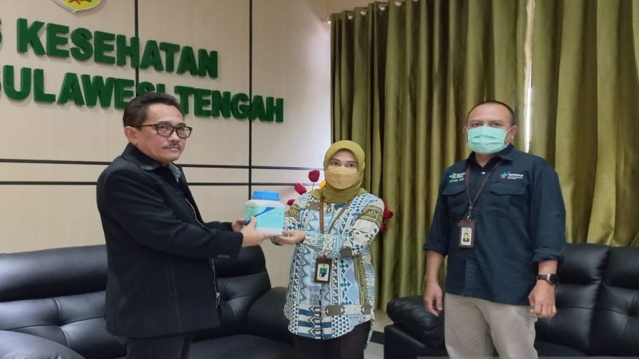Pejabat Direktorat Pencegahan dan Pengenendalian Penyakit Menular (P2PM) Kemenkes, Lusi Leviana (kanan) menyerahkan obat demam keong atau schistosomiasis kepada Kepala Dinas Kesehatan Sulteng, I Komang Adi Sudjendra (kiri) di Palu, Jumat (03/02/2023). ANTARA/Kristina Natalia