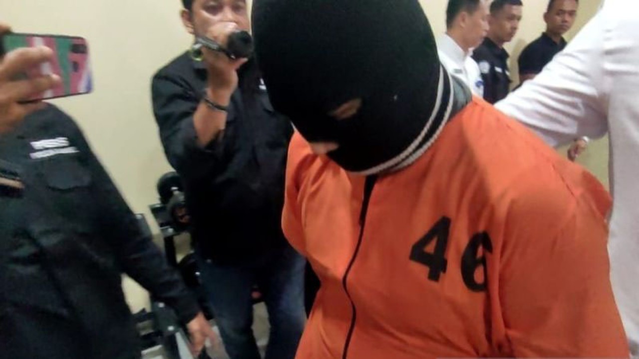 Tersangka pedofilia berbasis internet, berinisial TH, saat digiring personel Subdit V Direktorat Reserse Kriminal Khusus Kepolisian Daerah Sumatera Selatan ke ruang tahanan seusai dihadirkan dalam pengungkapan kasus di Palembang, Rabu (8/2/2023) (ANTARA/M Riezko Bima Elko P)