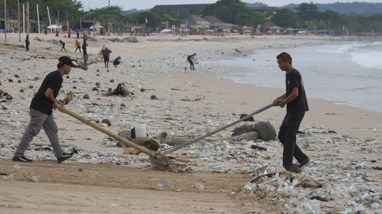 Sejumlah pekerja membersihkan sampah terdampar akibat cuaca ekstrem di Pantai Kedonganan, Badung, Bali, Kamis (9/2/2023). ANTARA FOTO/Nyoman Hendra Wibowo/nym/aa.