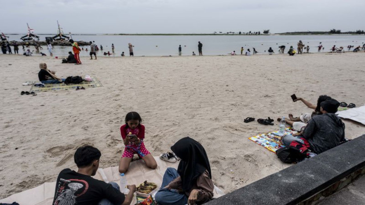 Pengunjung berwisata di Pantai Lagoon Ancol, Jakarta, Jumat (3/2/2023). ANTARA FOTO/Aprillio Akbar/hp.