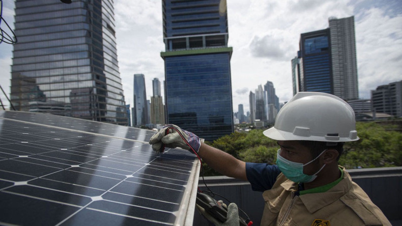 Petugas merawat panel surya yang terpasang di atap Gedung Direktorat Jenderal (Dirjen) Ketenagalistrikan Kementerian Energi dan Sumber Daya Mineral (EDSM), Jakarta, Rabu (24/3/2021). Kementerian ESDM hingga Maret 2021 telah membangun sebanyak 193 unit PLTS atap gedung, sementara sepanjang 2021-2030 pemerintah juga menargetkan pembangunan PLTS dengan kapasitas sebesar 5,432 Mega Watt untuk menurunkan emisi hingga 7,96 juta ton karbondioksida. ANTARA FOTO/Aditya Pradana Putra/rwa.