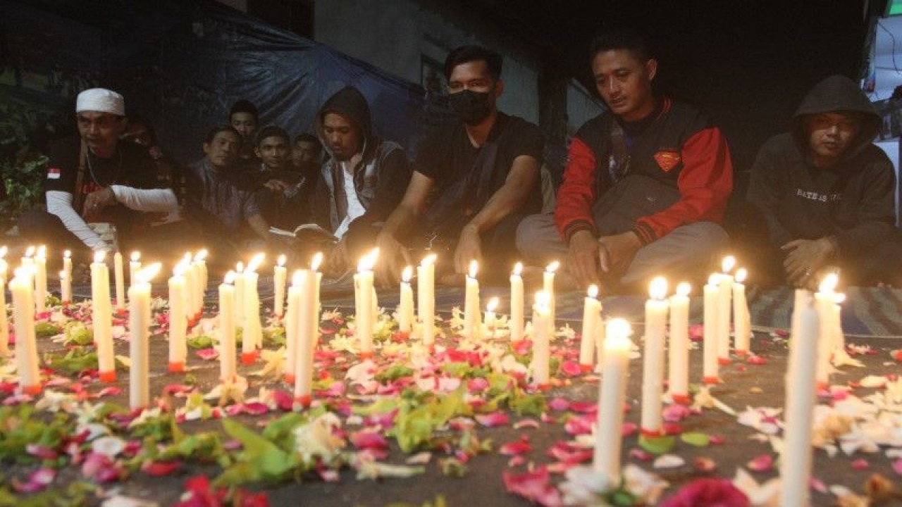 Foto arsip - Sejumlah warga dan suporter Arema FC (Aremania) mengikuti kegiatan doa bersama memperingati 100 hari Tragedi Kanjuruhan di Bandulan, Malang, Jawa Timur, Minggu (8/1/2023). Doa bersama tersebut untuk mendoakan dan mengenang 135 korban Tragedi Kanjuruhan dan sekaligus sebagai ungkapan keprihatinan terhadap lambatnya proses hukum terkait tragedi itu. ANTARA FOTO/Ari Bowo Sucipto/YU