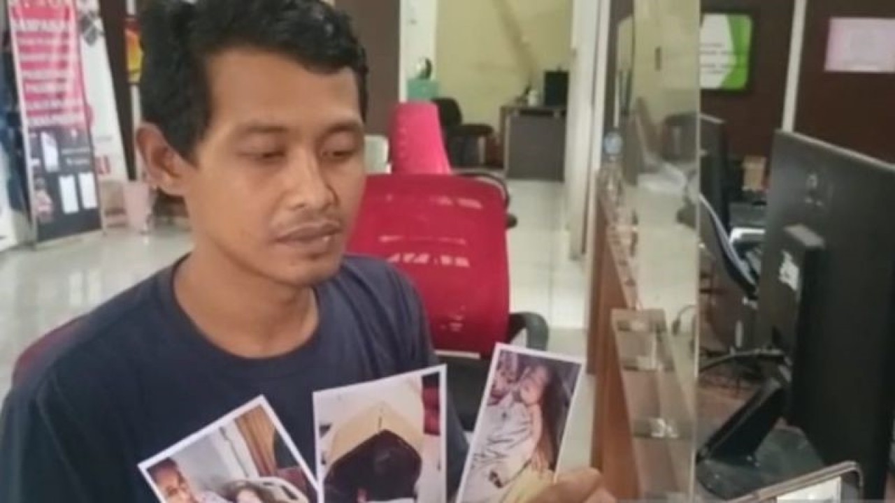 Suparman (38) menunjukkan foto anak bayinya yang terluka pada jari tangan bagian kelingkingnya akibat guntingan oknum perawat DN, saat membuat laporan di SPKT Polres Kota Besar Palembang, Sumatera Selatan, Sabtu (4/2/2023). ANTARA/M Riezko Bima Elko P.