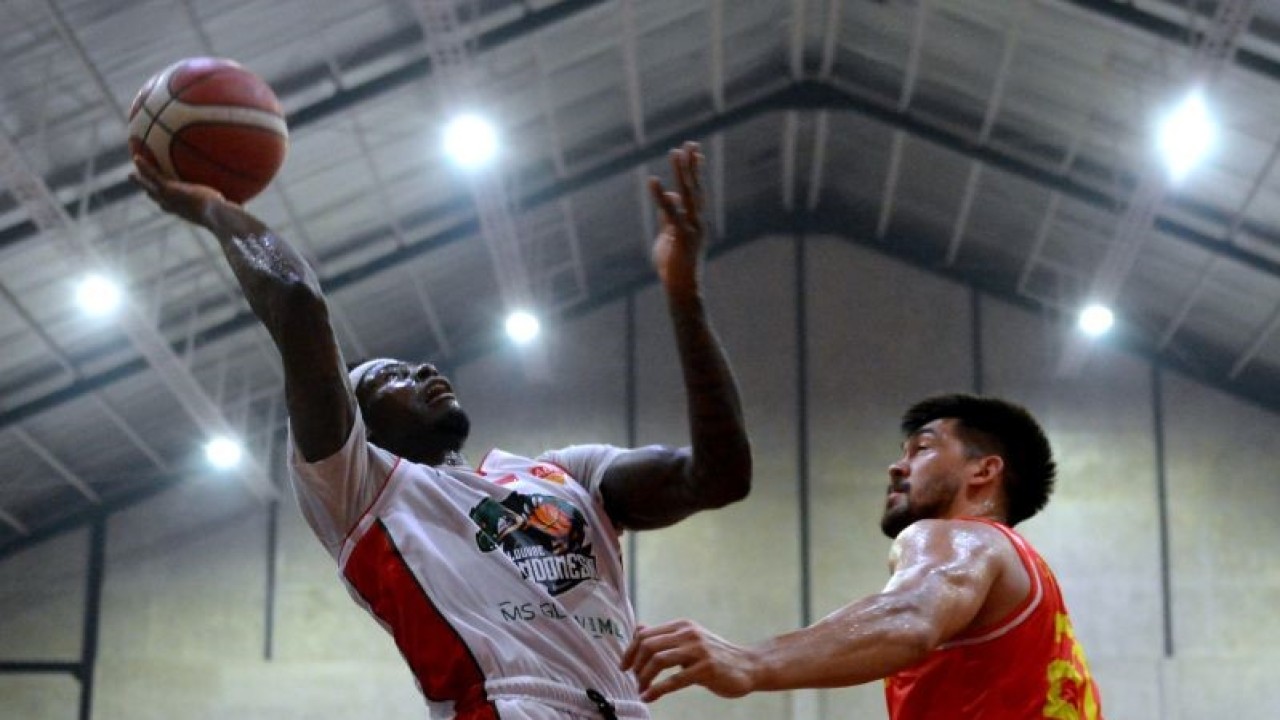 Pebasket Louvre Indonesia Michael Ayodele Kolawole (kiri) berusaha memasukkan bola ke basket melewati pebasket Tim Nasional Vietnam Christopher William Dierker (kanan) saat pertandingan penyisihan grup ABL Pre-SEA Games Challenge 2022 di Denpasar, Bali, Rabu (20/4/2022). . ANTARA FOTO/Fikri Yusuf/wsj. (ANTARA FOTO/FIKRI YUSUF)
