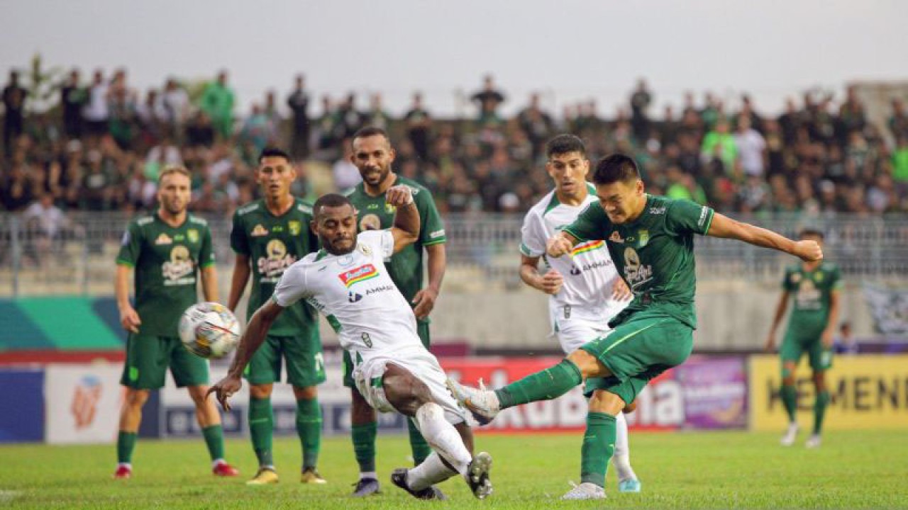 Pemain Persebaya Sho Yamamoto (kanan) dihadang oleh pemain PSS Sleman Marckho Merauke (kiri) saat menendang bola dalam laga lanjutan Liga 1 Indonesia musim. 2022/2023 di Stadion Gelora Joko Samudro Gresik, Senin (13/2/2023). (ANTARA/Rizal Hanafi)