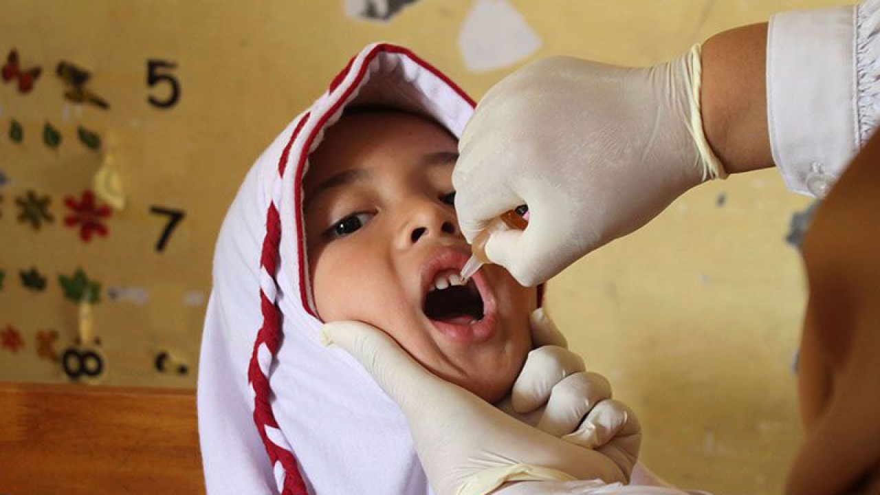 Petugas kesehatan memberikan tetesan vaksin polio tahap dua kepada pelajar di Sekolah Dasar Negeri 7, Banda Aceh, Senin (13/2/2023). ANTARA FOTO/Ampelsa