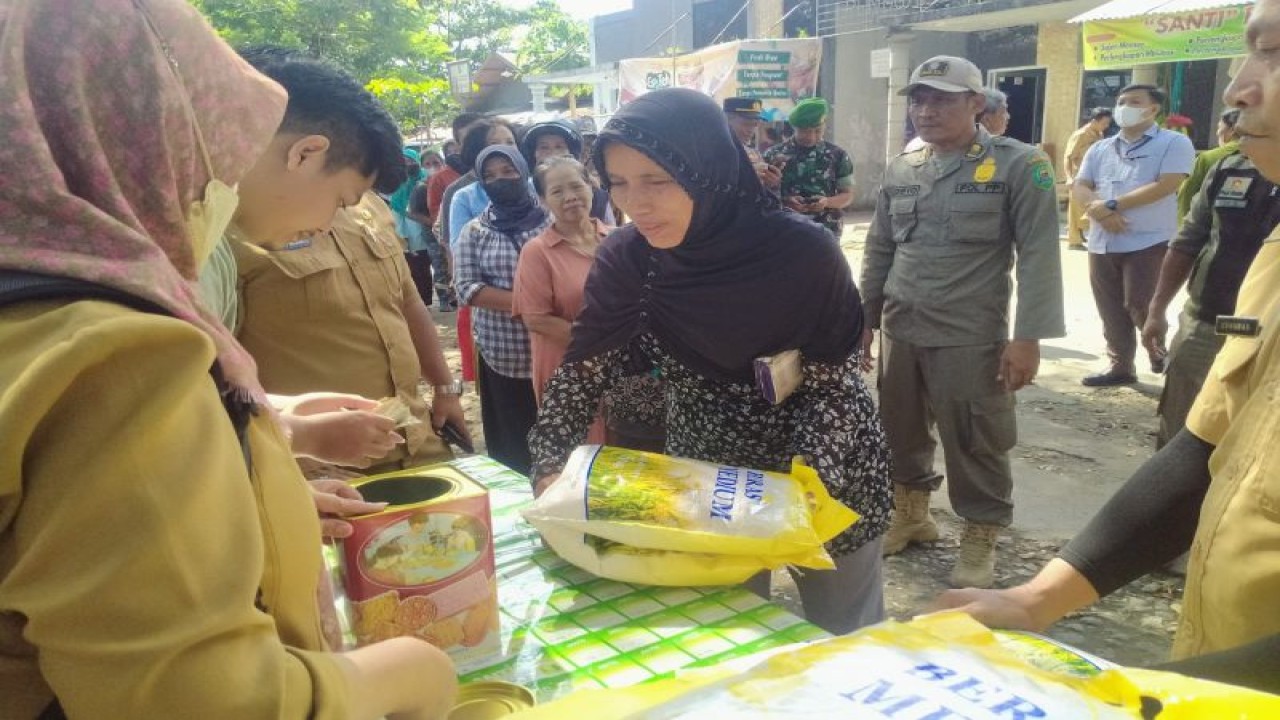 Petugas melayani pembelian beras murah dalam kegiatan operasi pasar beras di Pasar Subuh, Kabupaten Trenggalek, Jatim, Selasa (21/2/2023) (FOTO ANTARA/HO - Prokopim Trenggalek)