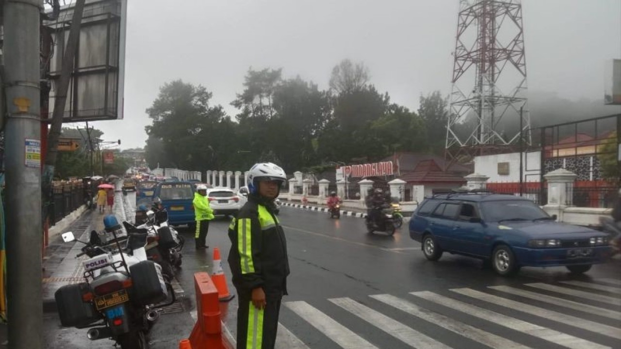 Polres Cianjur, Jawa Barat, menempatkan sejumlah petugas di jalur rawan macet di sepanjang Jalur utama Puncak-Cianjur, untuk mengimbau pengguna jalan seiring tingginya curah hujan, Minggu (19/2/2023).(ANTARA/Ahmad Fikri). (Ahmad Fikri)
