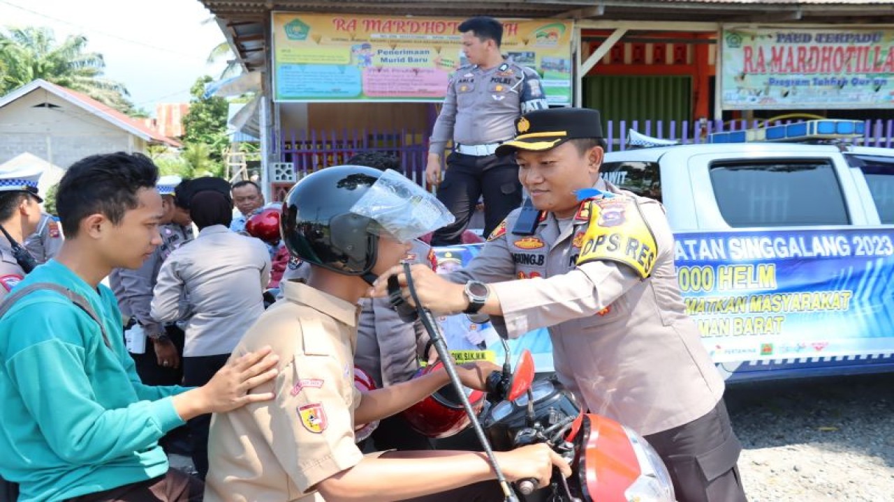 Kepala Polres Pasaman Barat AKBP Agung Basuki saat membagikan helm gratis kepada pengendara dalam Operasi Keselamatan Singgalang 2023 dalam upaya kampanye tertib berlalu lintas.