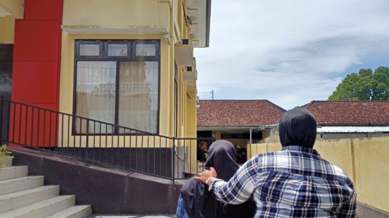 Petugas menggiring pelaku pencatutan nama polisi yang merupakan seorang IRT berinisial SHY (kiri) menuju ruang interogasi di Polresta Mataram, NTB, Selasa (14/2/2023). (ANTARA/Dhimas B.P.)