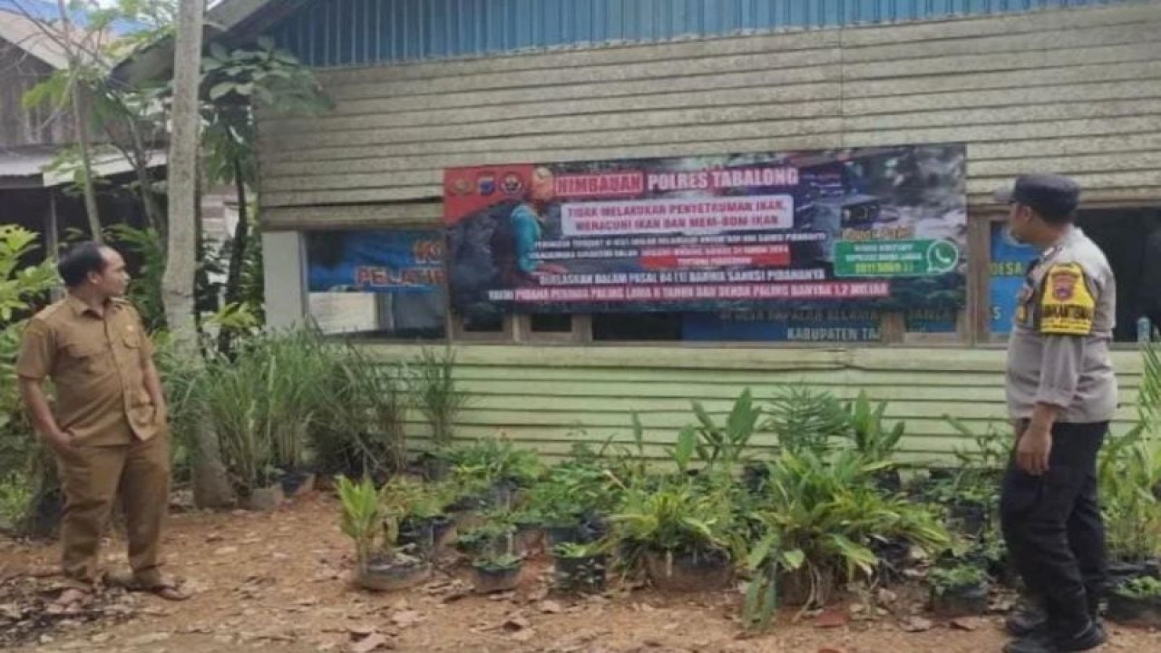 Petugas Bhabinkamtibmas Polsek Banua Lawas memasang spanduk larangan penyetruman ikan di Sungai Tabalong, Kecamatan Banua Lawas, Kabupaten Tabalong, Kalimantan Selatan. ANTARA/HO-Humas Polres Tabalong