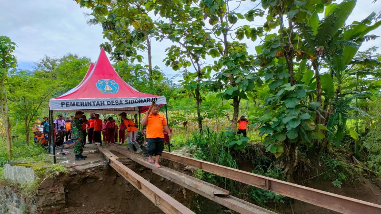 Petugas gabungan ber gotong-royong membangun jembatan darurat di Desa Sidoharjo Kecamatan Jambon, Ponorogo, Kamis (16/2/2023) (ANTARA/HO - BPBD Jatim)