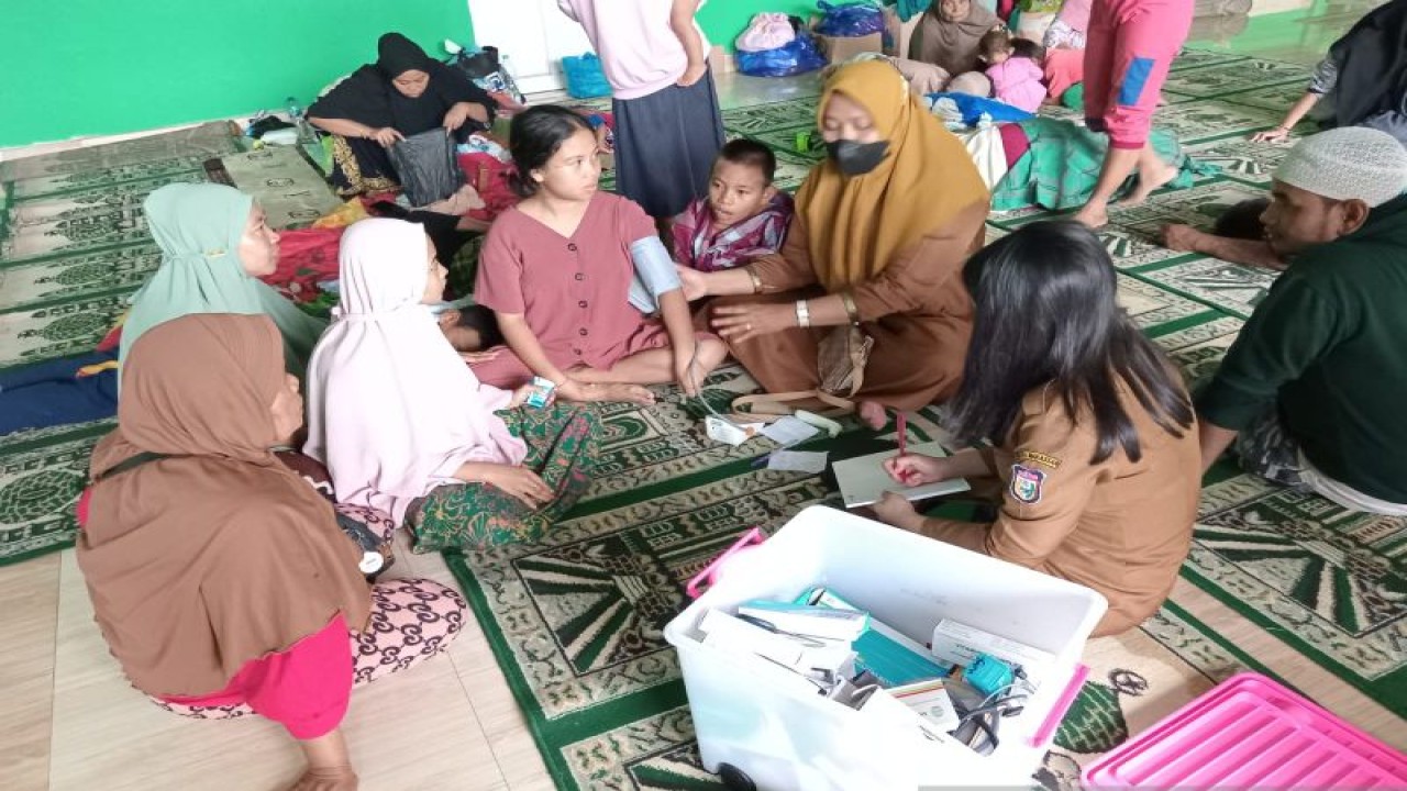 Tim medis Dinas Kesehatan Makassar memeriksa kondisi kesehatan korban banjir di posko pengungsian, Selasa (14/2/2023). ANTARA/HO/Pemkot Makassar