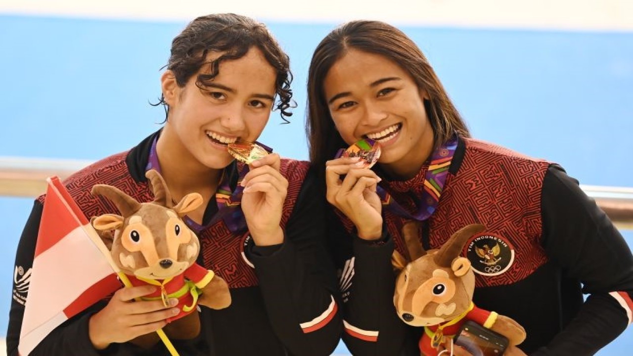 Perenang Indonesia Masriani Wolf (kiri) dan Anak Agung Istri Ratih Atmaja menggigit medali mereka usai pengalungan medali nomor 50 meter gaya punggung putri renang SEA Games 2021 Vietnam di Aquatic Sport Palace, Hanoi, Vietnam, Minggu (15/5/2022). ANTARA FOTO/Aditya Pradana Putra/YU (ANTARA FOTO/ADITYA PRADANA PUTRA)