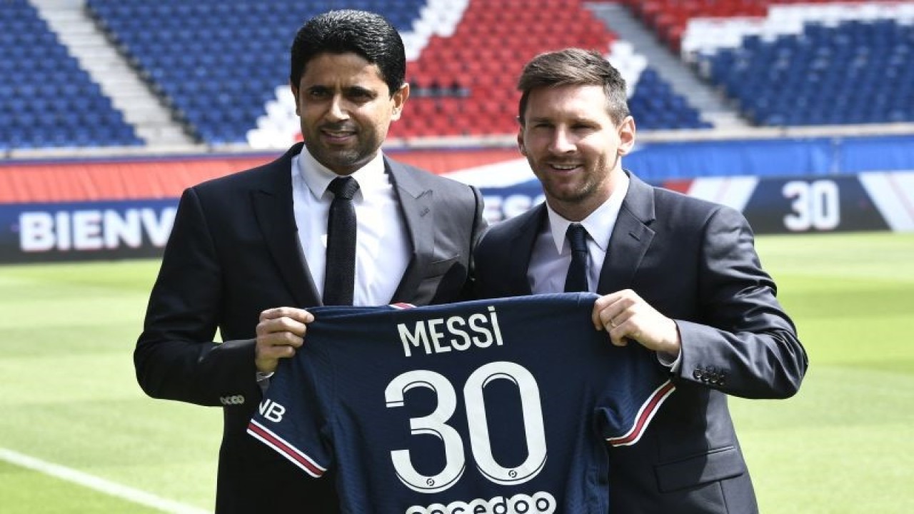 Presiden Paris Saint-Germain Nasser Al-Khelaifi (kiri) berfoto dengan striker Argentina Lionel Messi memegang kostum PSG bernomor punggung 30 untuk Messi di Stadion Parc des Princes, Paris, pada 1 Agustus 2021. (Photo by STEPHANE DE SAKUTIN / AFP) (AFP/STEPHANE DE SAKUTIN)