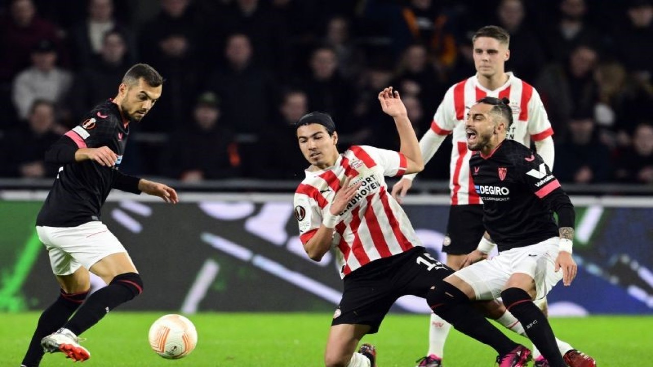 Gelandang PSV Eindhoven Erick Gutierrez (tengah) dan bek Sevilla Alex Telles (kanan) berjuang memperebutkan bola pada pertandingan leg kedua playoff Liga Europa yang dimainkan di Stadion Phillips, Eindhoven, Jumat (25/2/2023) dini hari WIB. (ANTARA/AFP/OLAF KRAAK)