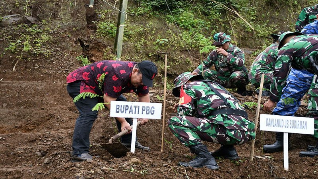 Asisten Bidang Pemerintahan dan Kesejahteraan Rakyat Sekretaris Daerah Purbalingga R Imam Wahyudi (berpakaian batik) menanam bibit pohon di bekas lokasi longsor, Dusun IV Sipetung, Desa Siwarak, Kecamatan Karangreja, Kabupaten Purbalingga, Kamis (23/2/2023). ANTARA/HO-Pemkab Purbalingga