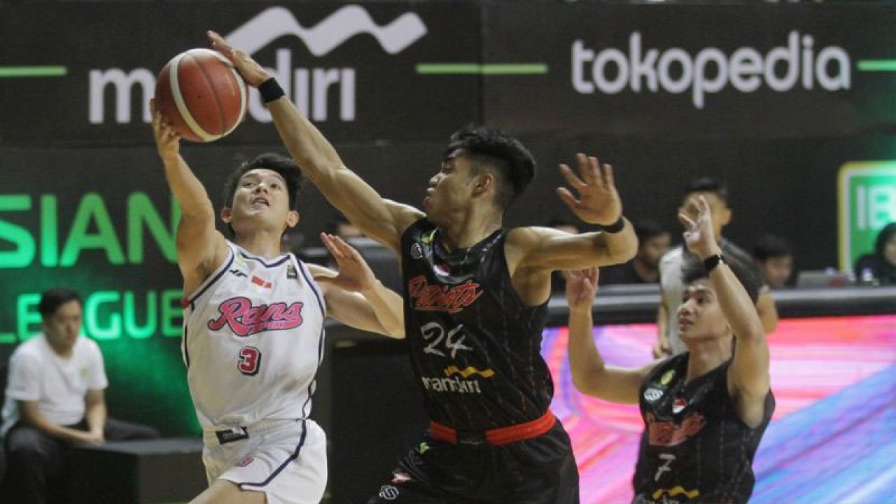 Pebasket RANS PIK Basketball Club Alexander Franklyn (kiri) berusaha memasukkan bola yang coba dihadang pebasket Indonesia Patriots Daniel William Tunasey Salamena (tengah) dalam pertandingan Indonesian Basketball League (IBL) 2023 Seri III di DBL Arena, Surabaya, Jawa Timur, Kamis (16/2/2023). RANS PIK Basketball Club mengalahkan Indonesia Patriots 68-62. ANTARA FOTO/Moch Asim/tom.