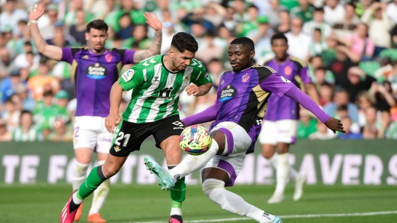 Penyerang Real Betis Ayoze Perez (kiri) berduel memperebutkan bola dengan bek Real Valladolid Martin Hongla (kanan) pada pertandingan Liga Spanyol yang dimainkan di Stadion Benito Villamarin, Seville, Sabtu (18/2/2023). (ANTARA/AFP/CRISTINA QUICLER)