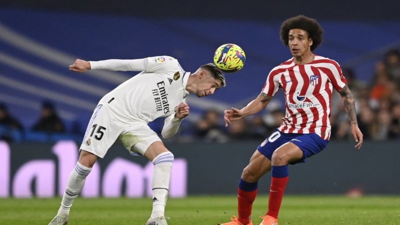 Gelandang Real Madrid Federico Valverde (kiri) berduel memperebutkan bola dengan gelandang Atletico Madrid Axel Witsel pada pertandingan Liga Spanyol yang dimainkan di Stadion Santiago Bernabeu, Madrid, Sabtu (25/2/2023). (ANTARA/AFP/OSCAR DEL POZO)