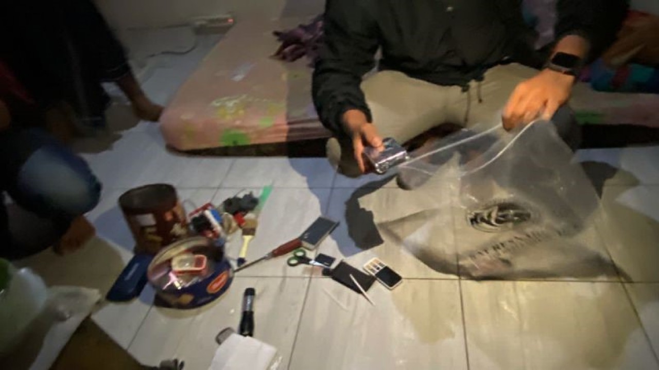 Petugas kepolisian mengumpulkan barang bukti yang berkaitan dengan kasus narkoba dalam giat penggeledahan di rumah terduga pengedar sabu-sabu di Abian Tubuh, Mataram, NTB, Rabu dinihari (22/2/2023). (ANTARA/Dhimas B.P.)