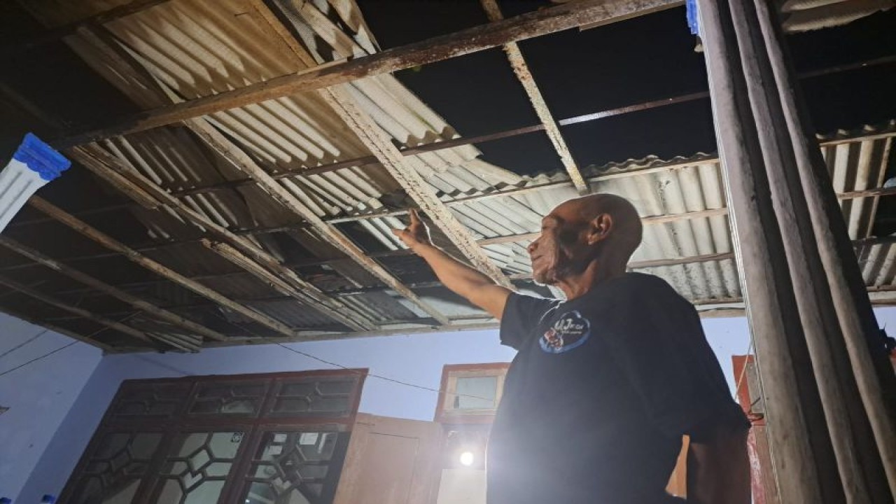 Bardo menunjukkan atap rumahnya yang jebol dan tersingkap akibat hempasan angin yang dipicu putaran baling-baling helikopter Kapolda Jatim yang mendarat darurat di lapangan Desa Rejotangan, Tulungagung, Rabu (22/2/2023) malam. (ANTARA/HO - foto warga)
