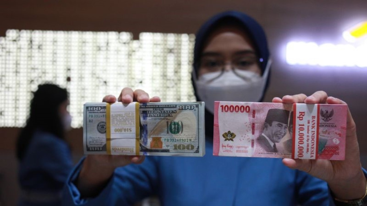 Petugas menunjukkan uang dolar AS dan uang rupiah di salah satu kantor cabang PT. Bank Mandiri Persero Tbk, Jakarta, Selasa (31/1/2023). ANTARA FOTO/Reno Esnir/tom. (ANTARA FOTO/RENO ESNIR)