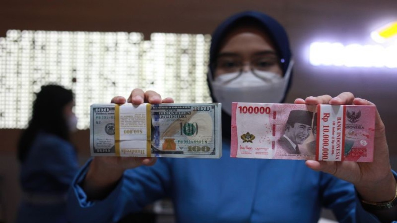Ilustrasi - Petugas menunjukkan uang dolar AS dan uang rupiah di salah satu kantor cabang PT Bank Mandiri Persero Tbk, Jakarta, Selasa (31/1/2023). ANTARA FOTO/Reno Esnir/tom/pri.