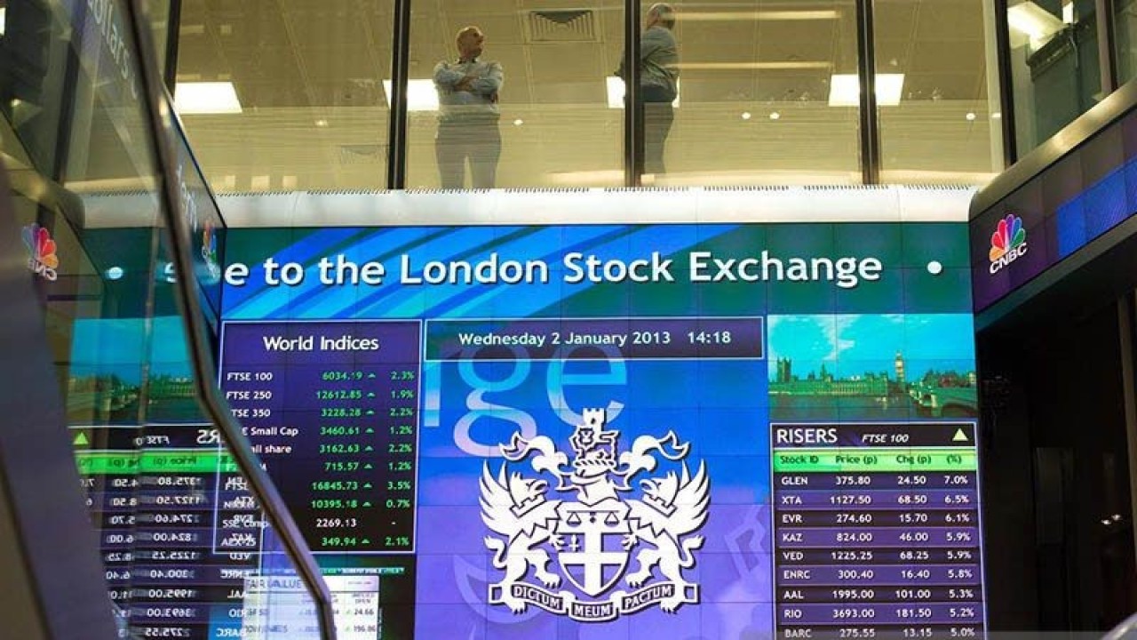 Pekerja terlihat berbincang di atas papan elektronik pergerakan saham di London Stock Exchange, Inggris. REUTERS/Paul Hackett/aa. (REUTERS/Paul Hackett)