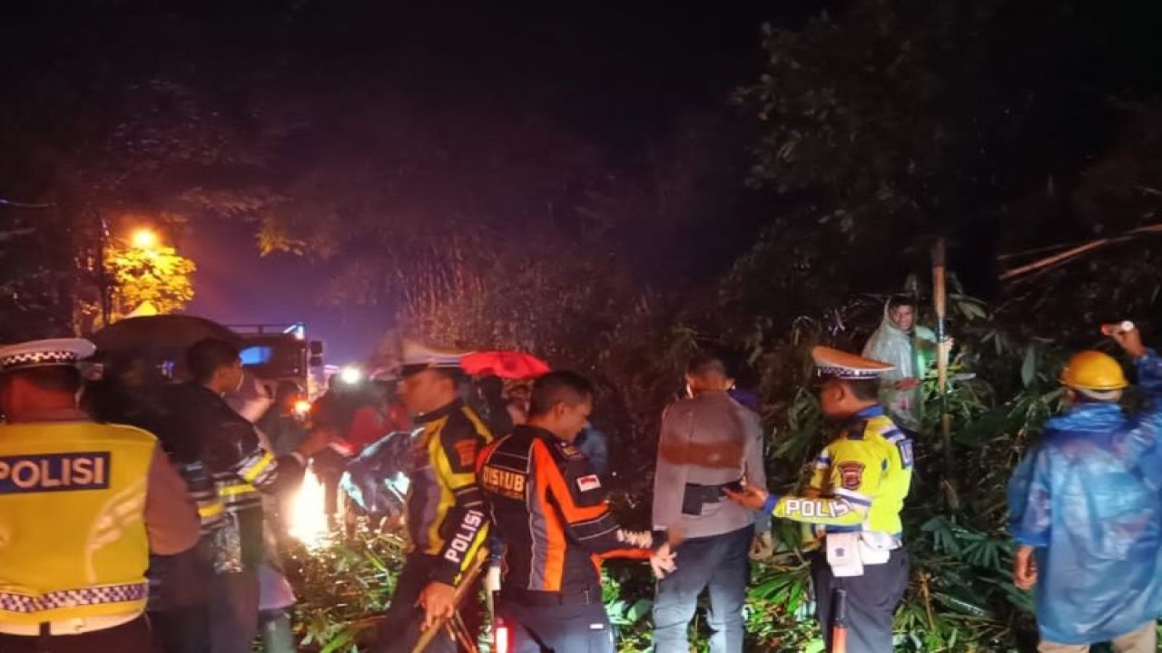 Sejumlah anggota polisi dan warga sedang membersihkan material longsor. (ANTARA/HO)