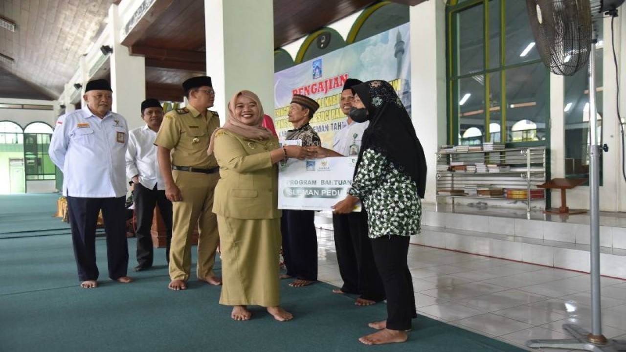 Bupati Sleman Kustini Sri Purnomo menyerahkan bantuan dari Baznas Sleman pada peringatan Isra' mi'raj Nabi Muhammad SAW bagi ASN di lingkungan Pemerintah Kabupaten Sleman di serambi Masjid Agung Sleman, Senin (20/2/2023). ANTARA/HO-Bagian Prokopim Setda Sleman