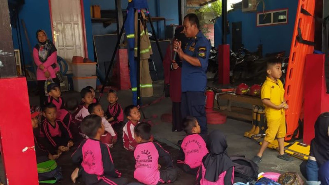 Petugas Dinas Pemadam Kebakaran memberikan penjelasan kepada siswa pendidikan anak usia dini dan taman kanak-kanak mengenai upaya pemadaman kebakaran di Kota Palu, Provinsi Sulawesi Tengah, Kamis (9/2/2023). (ANTARA/HO-Humas Pemkot Palu)