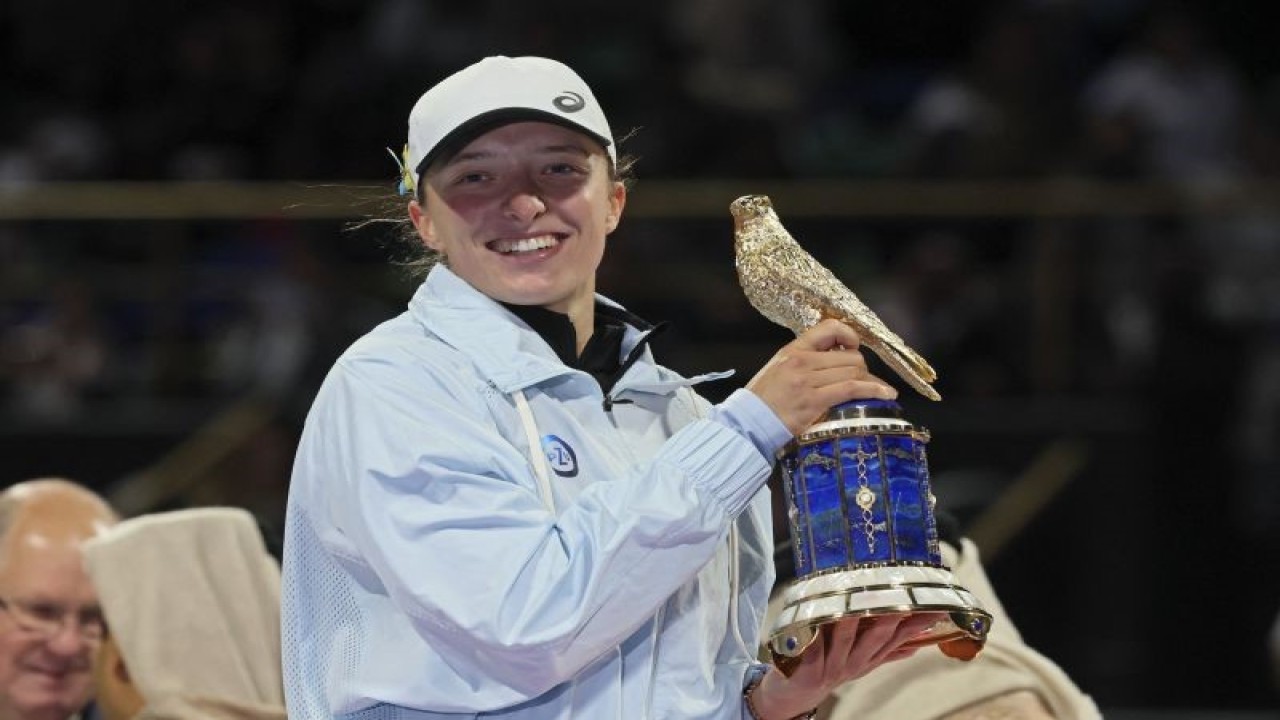 Petenis Polandia Iga Swiatek merayakan keberhasilannya menjuarai Qatar Open setelah mengalahkan Jessica Pegula pada pertandingan final yang dimainkan di Kompleks Khalifa International Tennis and Squash complex, Doha, Sabtu (18/2/2023) malam WIB. (ANTARA/AFP/KARIM JAAFAR)