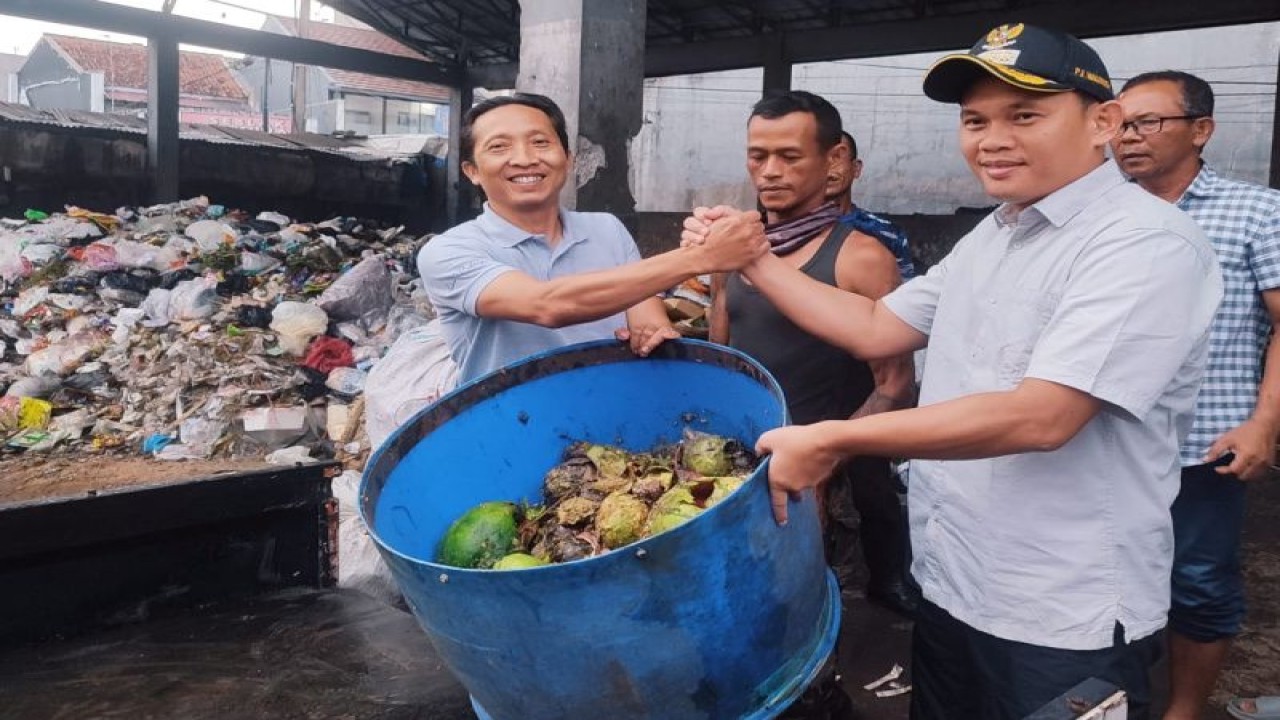 Penjabat Wali Kota Tasikmalaya Cheka Virgowansyah (kanan) menyerahkan sampah organik kepada pengusaha maggot di Kota Tasikmalaya, Jawa Barat.  ANTARA/HO-Diskominfo Kota Tasikmalaya