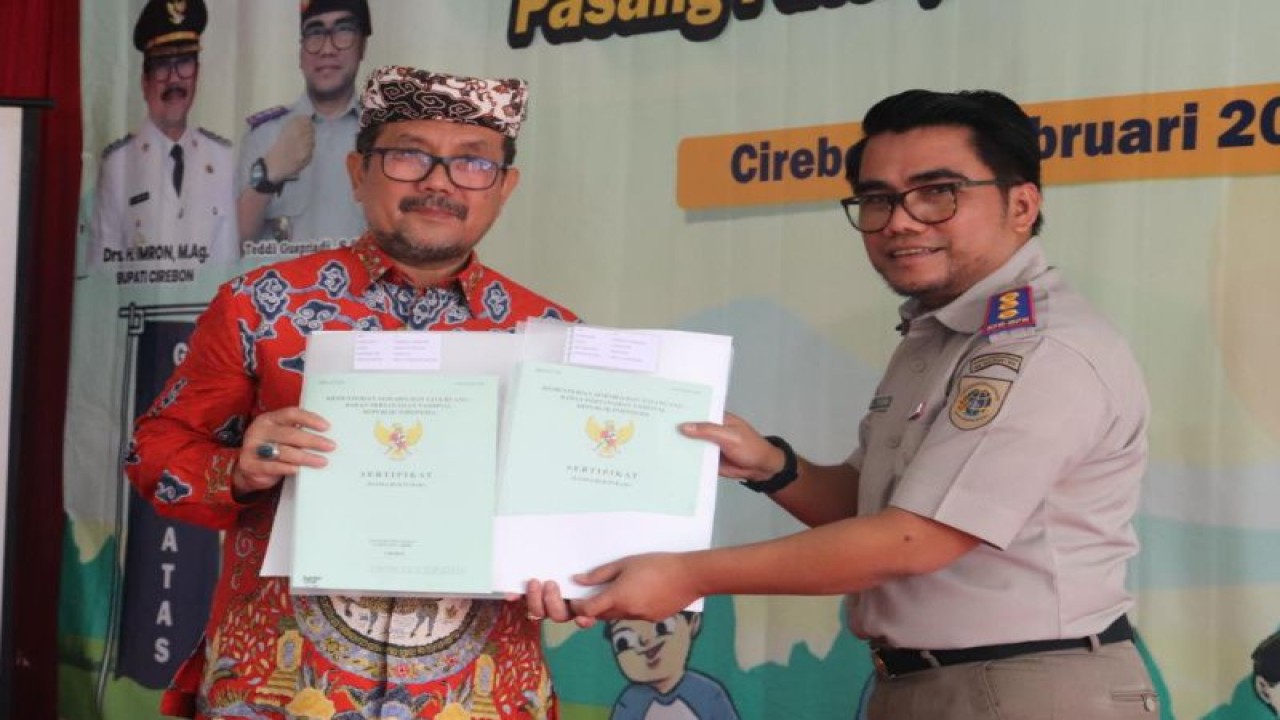 Kepala BPN Kabupaten Cirebon Teddi Guspriadi (kanan) memberikan sertifikat tanah kepada Bupati Cirebon Imron di Cirebon, Jawa Barat, Jumat (3/2/2022). (ANTARA/Ho-Humas)