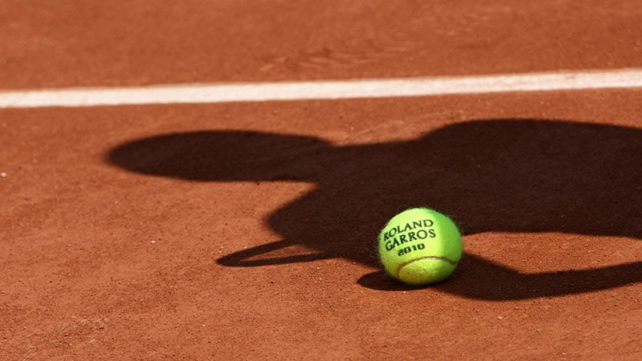 ilustrasi - Bola resmi turnamen tenis dengan bayang-bayang seorang pemain tenis diatas tanah. ANTARA/Shutterstock/pri.