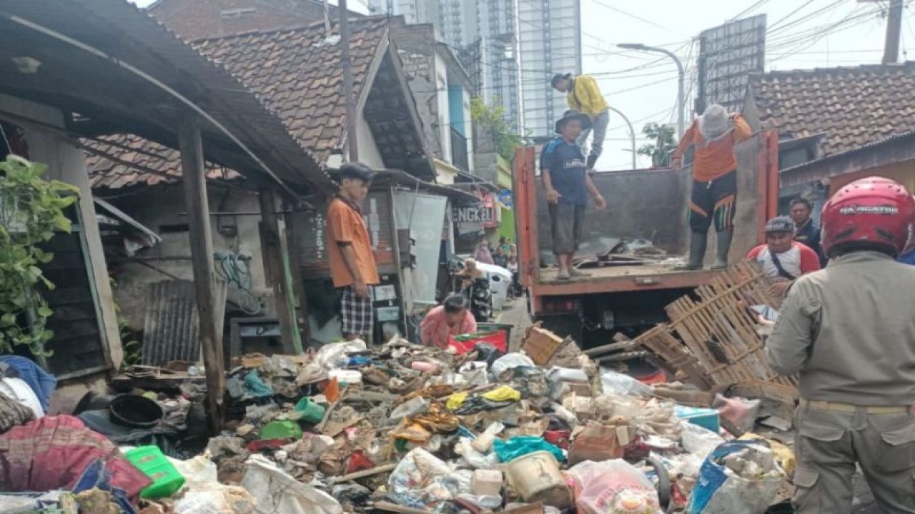 Sejumlah petugas Dinas Lingkungan Hidup (DLH) menangani tumpukan sampah di rumah salah seorang warga di Jemur Gayungan I Kota Surabaya, Jatim, Rabu (15/2/2024). (ANTARA/HO-DLH Surabaya)