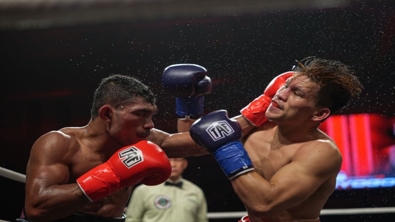 Petinju Indonesia Hebi Marapu (kiri) melakukan pukulan ke arah Al Toyogon dalam laga perebutan juara kelas ringan IBA Intercontinental di Johor Bahru, Malaysia, Minggu (25/12/2022). (ANTARA/HO-XBC Sportech)