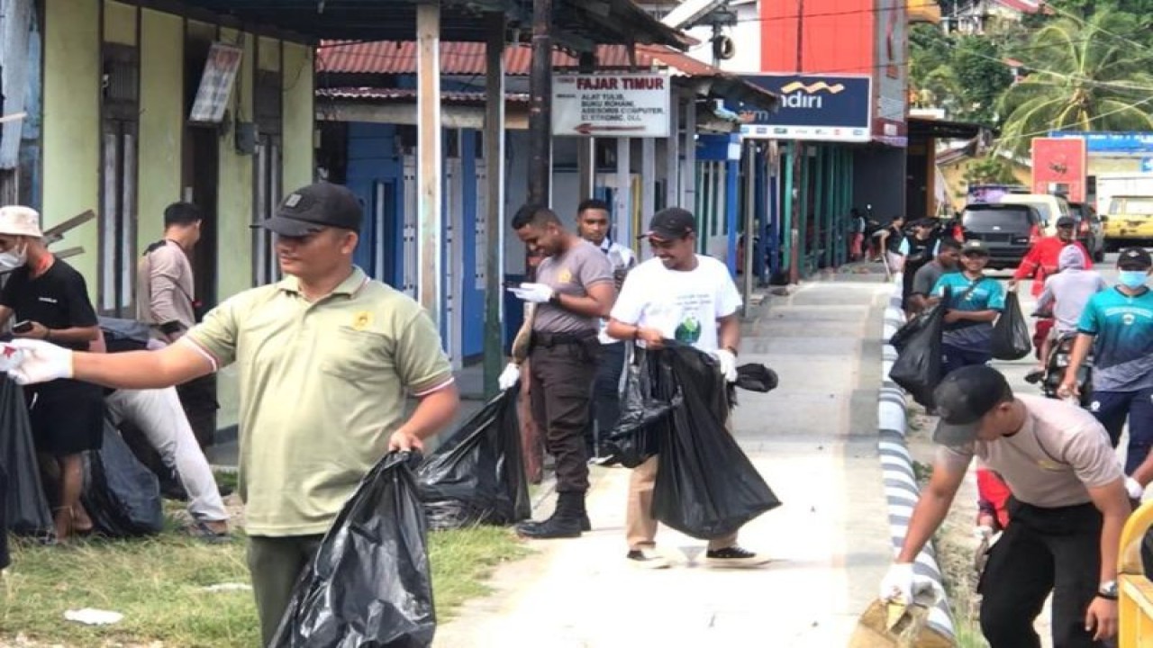 Warga bersama anggota TNI dan Polri membersihkan sampah di jalan-jalan utama Kota Kaimana, Papua Barat. (ANTARA/HO-Isabela Wisang)