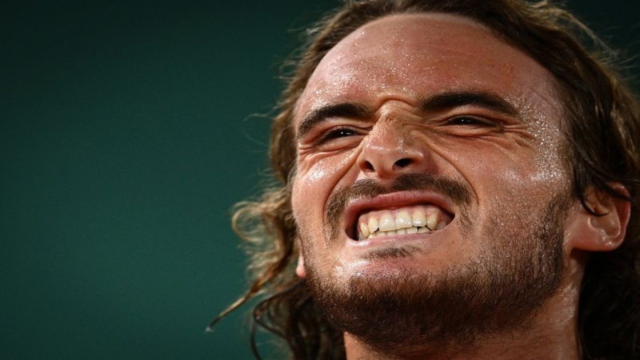 Arsip - Stefanos Tsitsipas berteriak seusai mengalahkan Daniil Medvedev dalam perempat final French Open 2021 di Paris, Selasa (8/6/2021. AFP/Christophe ARCHAMBAULT