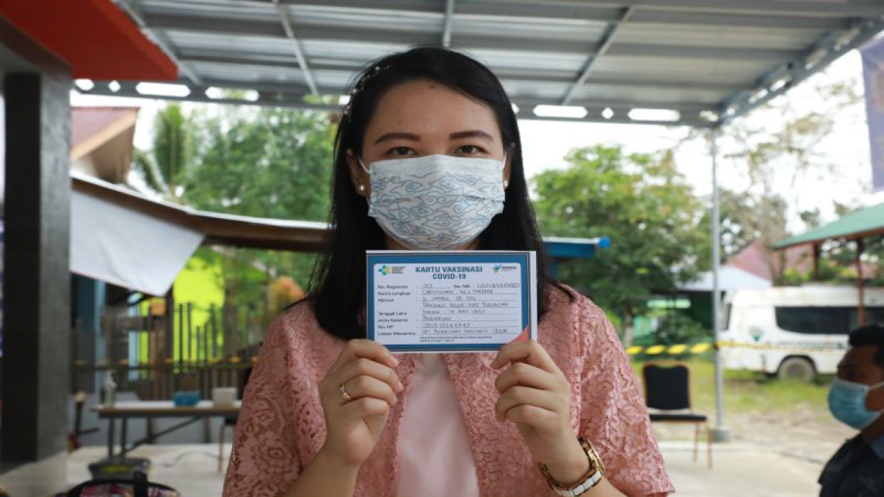Seorang tenaga kesehatan memperlihatkan kartu vaksinasi usai simulasi pelaksanaan vaksinasi COVID-19 di Tanjung Selor, Kabupaten Bulungan, Provinsi Kalimantan Utara. (ANTARA/Muh. Arfan)