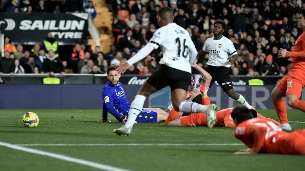 Kiper Real Sociedad Alex Remiro (baju biru) gagal menghentikan bola yang terkena Igor Zubeldia untuk masuk ke gawangnya, pada pertandingan Liga Spanyol melawan Valencia yang berlangsung di Stadion Mestalla, Valencia, Sabtu (25/2/2023). (ANTARA/AFP/JOSE JORDAN)