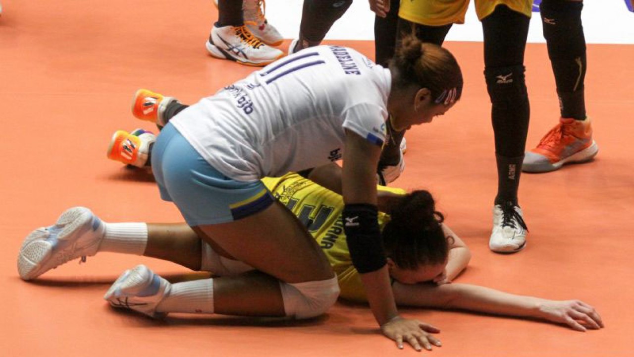 Pemain Bandung bjb Tandamata Madeline Jazmin (kiri) mendekati pemain Gresik Petrokimia Bohdana Anisova yang tergeletak setelah mukanya terkena bola smes saat pertandingan final four di GOR Tri Dharma Petrokimia Gresik, Jatim, Sabtu (25/2/2023) malam. (ANTARA/Umarul Faruq)