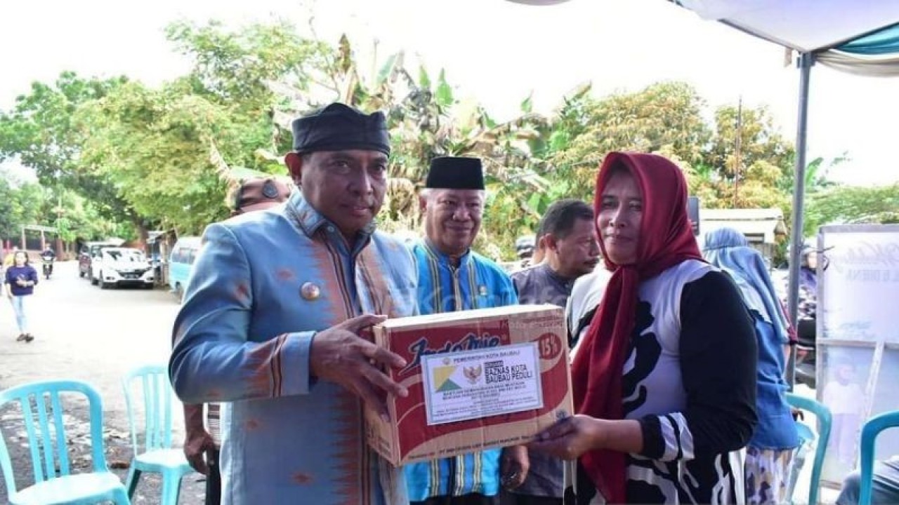 Walikota Baubau La Ode Ahmad Monianse (kiri) saat menyerahkan bantuan sembakio dari Baznas Kota Baubau kepada keluarga korban kebakaran. (ANTARA/HO)