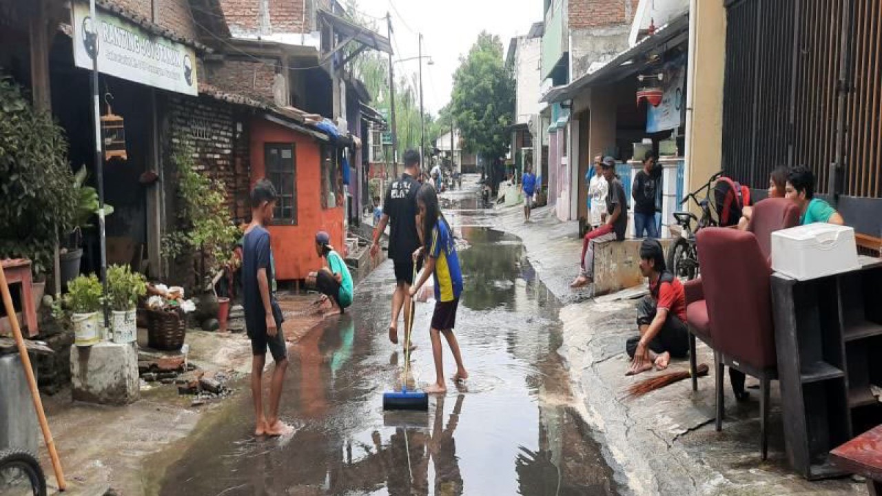 Sejumlah warga sedang membersihkan jalan dari sisa sampah dan lumpur banjir di Keluarhan Joyotakan Serengan Solo, Sabtu (18/2/2023). ANTARA/Bambang Dwi Marwoto.