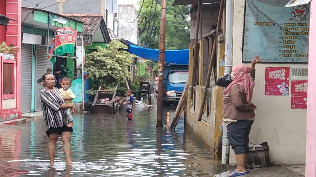 Warga beraktivitas di tengah genangan setelah hujan lebat mengguyur permukiman di dekat Stasiun Kalideres, Jakarta Barat, Senin (27/2/2023). ANTARA/Dewa Ketut Sudiarta Wiguna