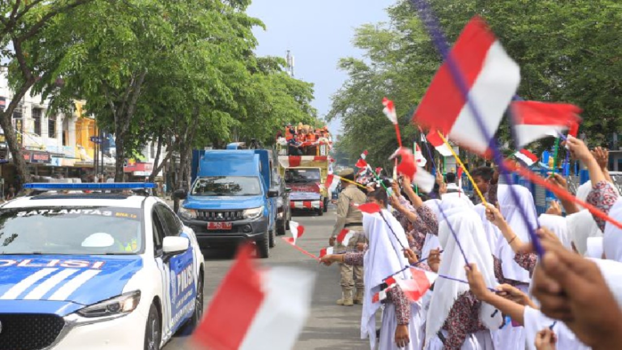 Pelajar menyambut iring-iringan kendaraan yang mengikuti pawai Piala Adipura 2022 di Jalan Tentara Pelajar, Banda Aceh, Aceh, Rabu (1/3/2023). (ANTARA/Khalis Surry)
